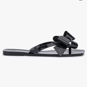 Black shiny flip-flop with a structured bow